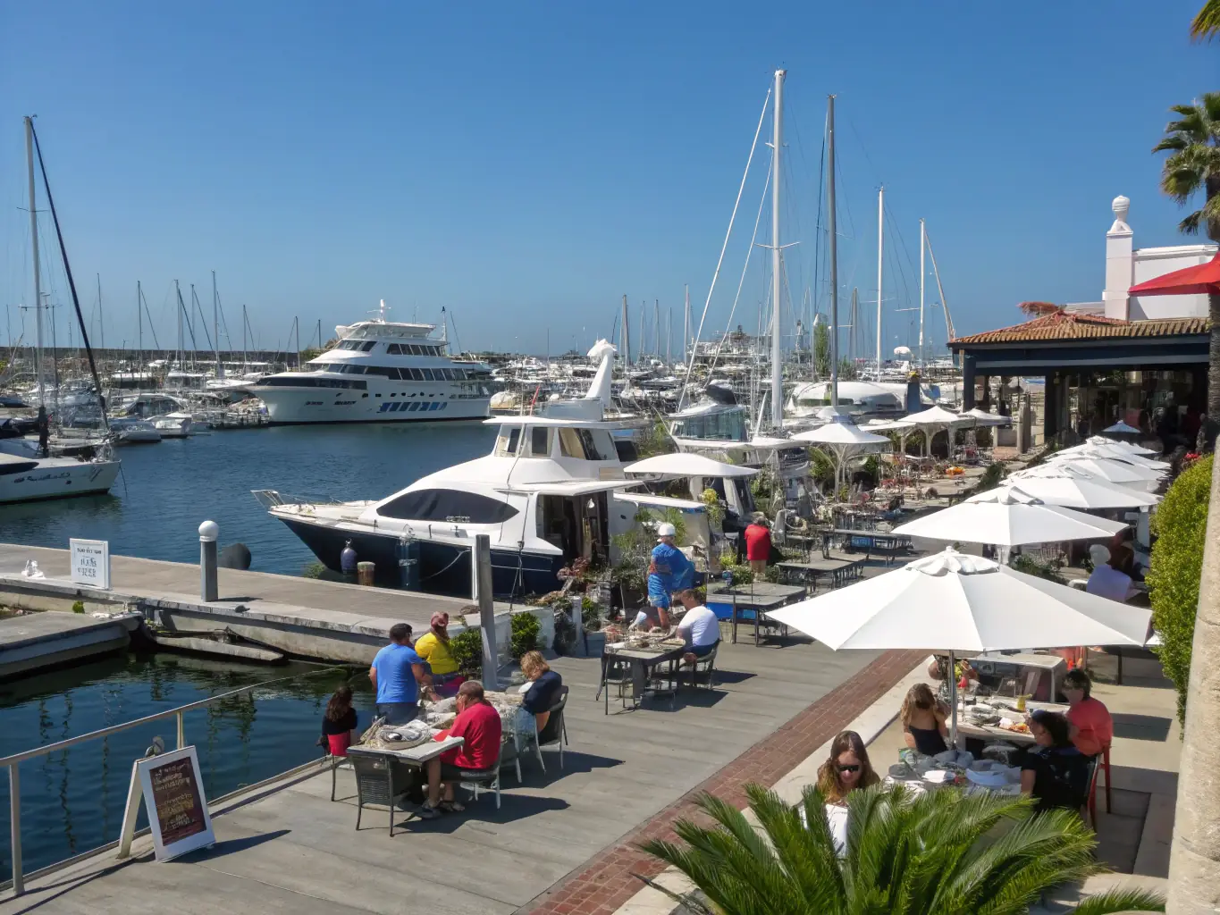 A vibrant scene of community members participating in a waterfront event organized by RAM'EN RANCE, emphasizing the organization's focus on community engagement and social cohesion.