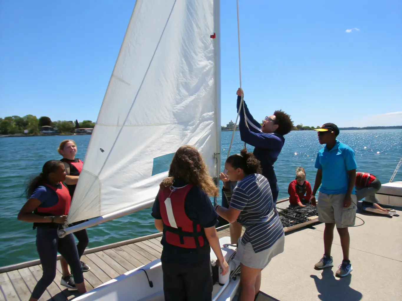 A diverse group of individuals participating in an adaptive sailing program, highlighting RAM'EN RANCE's commitment to accessible sports and inclusivity.
